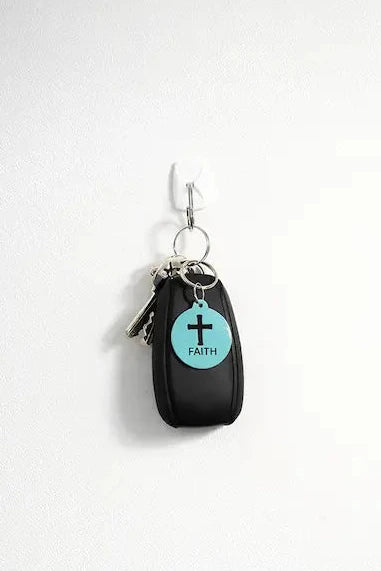 NFC keychain shown on a set of keys. Teal NFC keychain with black cross and "FAITH" black text.